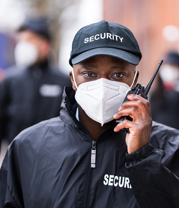 Security-Guard-Talking-On-Walkie-talkie-wearing-mask